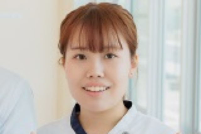 仲間スタッフとの作業の手を休めて撮影。元気な笑顔です。